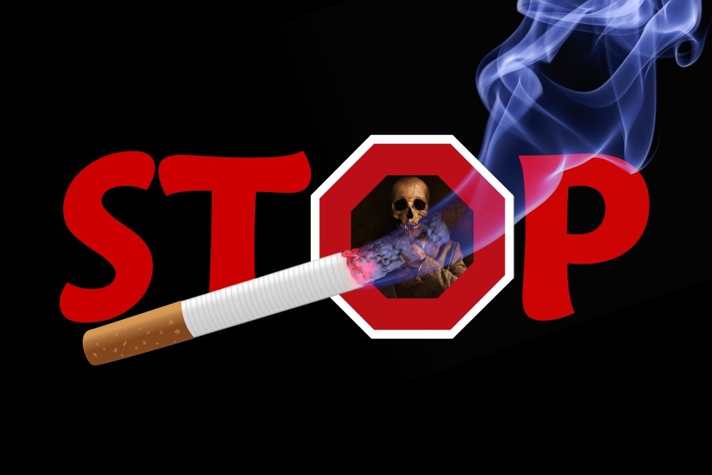 Nápis STOP so smrtkou zobrazenou v písmene O. V popredí je horiaca cigareta.
